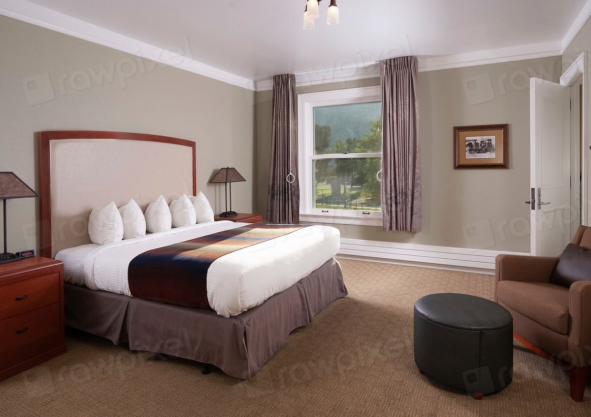 A guest room with a large bed and soft lighting